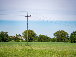 droga elektryczna na środku łąki, krajobraz w rejonie zachodniej polski zielone drzewa błękitne niebo