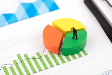 Businessman on a creative pie chart in miniature