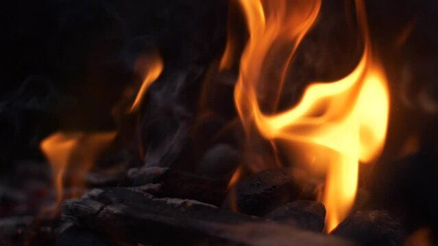 Slow motion detail of wood and charcoal fire burning