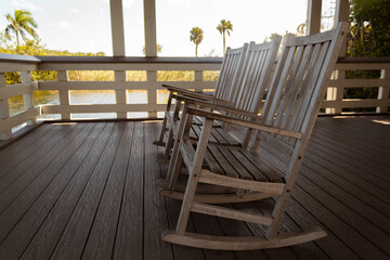 Three wooden rocking chairs in a log cabin