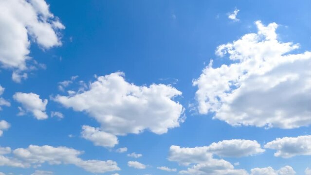 Puffy white clouds appearing in the blue clear sky. Picturesque timelapse quickly moving in the skyline.
