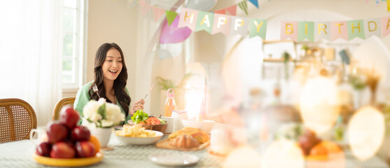 Beautiful happy asian woman her birthday in living room at home.Girl with cake.Birthday or New Year's eve celebration concept