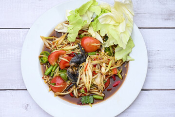 Thai food papaya salad with cabbage yard long bean on white plate , papaya salad with crab and fermented fish