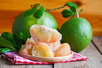 pomelo fruit on wooden background, fresh green pomelo peeled on plate and green leaf frome pomelo...