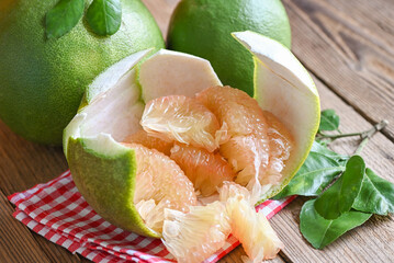 pomelo fruit on wooden background, fresh green pomelo peeled on pomelo skin and leaf frome pomelo...
