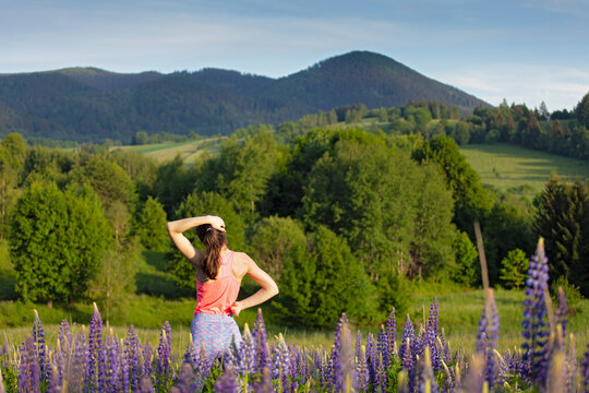 woman streaching back and neck on wild mountain landscape, natural clean environment, sport healthy life style concept.