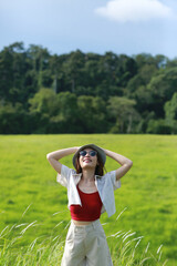 Obraz premium girl wearing sunglasses and causual outfit,looking to the sky,relaxing in nature,hill as background