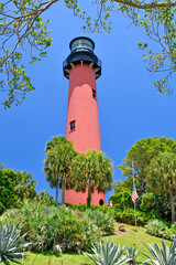 Historic red brick Jupiter lighthouse under clear blue skies at Jupiter Inlet, Florida