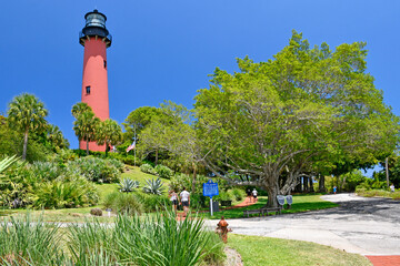 Tourists visiting the historic red brick Jupiter lighthouse against blue skies at Jupiter Inlet, Florida © Ryan Tishken