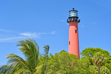 Historic red brick lighthouse against a clear blue sky in Jupiter, Florida