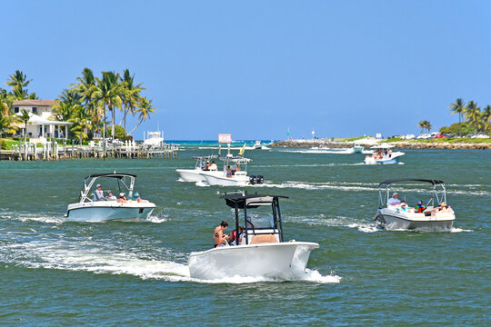 Boats battle against the current of the outgoing tide in the river channel at Jupiter Inlet, Florida