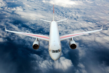Passenger plane in flight. Aircraft fly high in the sky above the clouds. Front view.
