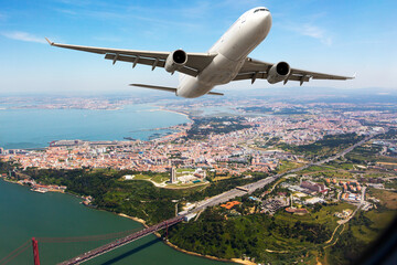 White passenger plane in flight. The plane flies against a background of city and river.