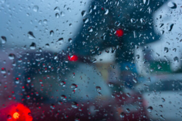 Blurred image of raindrops falling on wet glass, abstract blurs of traffic - monsoon stock image of Kolkata (formerly Calcutta) city ,