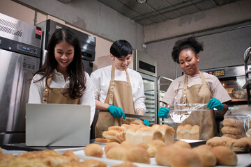 Three young friends and startup partners of bread dough and pastry foods busy with homemade baking...