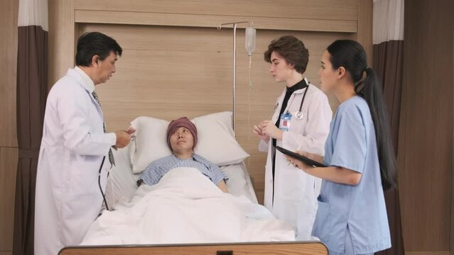 Professional doctors team in uniform health check Asian recovery male patient by stethoscope, medicine treatment at inpatient room bed in hospital ward, medical clinic, cancer examination consult.