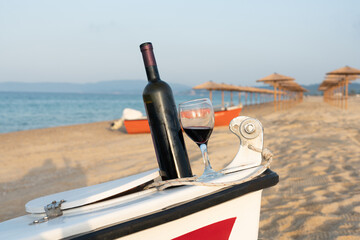 A bottle of red wine carelessly left on the prow of a fishing boat