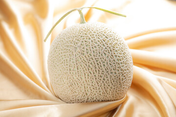 シャンパンゴールドのシルク生地の背景にアールスメロン