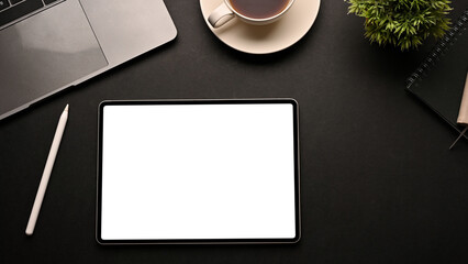 Obraz na płótnie Canvas Trendy black workspace background with digital tablet blank screen mockup. top view