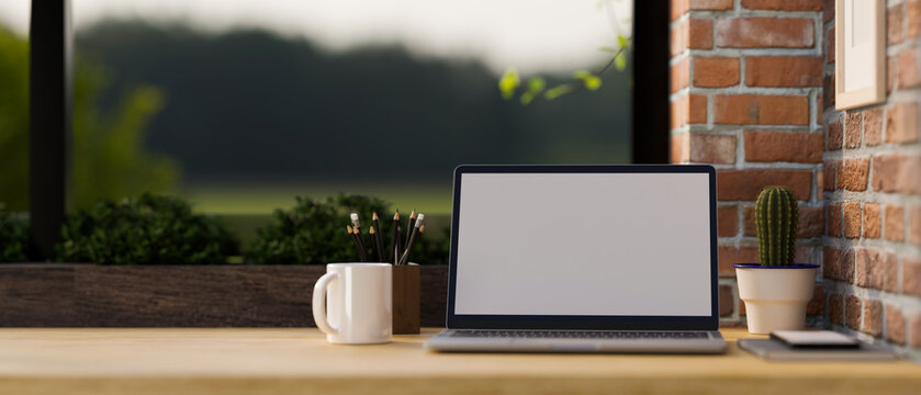 Vintage workspace with portable laptop and copy space on wood table with red brick wall.
