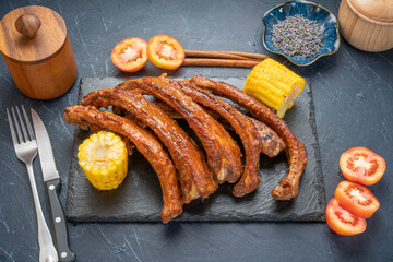 Honey BBQ Pork Ribs, Pork Spare Ribs with Barbecue spicy sauce, Grilled sliced barbecue pork ribs on black plate.