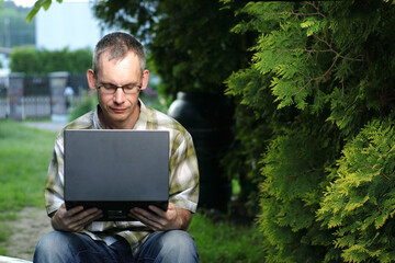 person holding a laptop on the bench