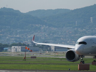 晴れた日に離陸を待つ旅客機と吹き流し