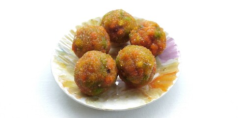 Traditional indian, pakistani and bangladesh festival party sugary ball sweets laddu also known as laddoo, ladoo, lado, meetha or mithai dessert in plate isolated on white background and copy space.
