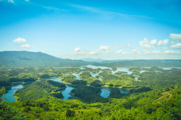Obraz premium Morning at the Ta Dung lake or Dong Nai 3 lake with green hills and mountains. Travel and landscape concept. Travel concept.