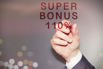 Business man writing with a red pen “super bonus 110%” .