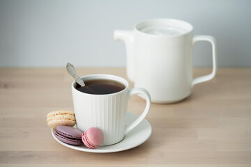 Tea time. Cup of tea with a teapot and macaroon.