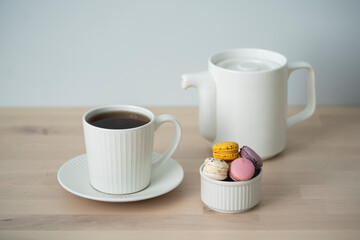 Tea time. Cup of tea with a teapot and macaroon.