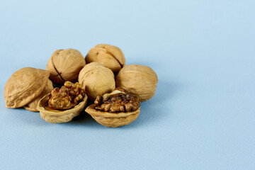 Walnut on a blue background in close-up. The concept - healthy fats, healthy heart.