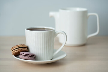 Сup of tea, a teapot and a cake on a blue background.