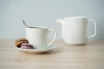 Tea time. Cup of tea with a teapot and macaroon.