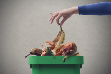 Woman putting organic waste in the recycling bin