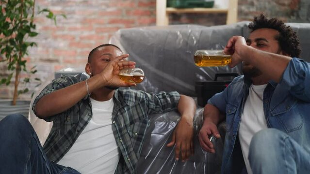Happy black friends celebrate repair end drinking beer