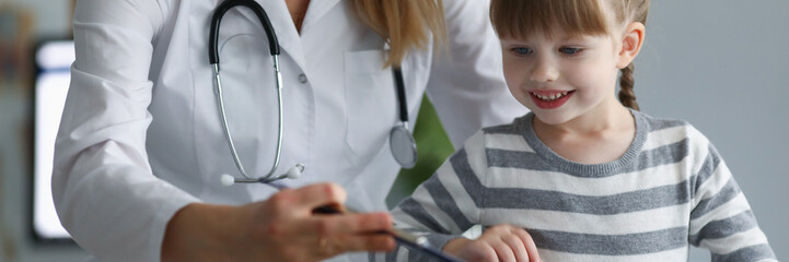Pediatrician female try to distract child attention and make diagnostic