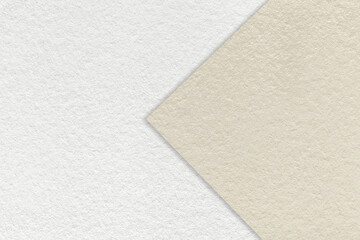 Texture of white and light beige paper background, half two colors with arrow, macro. Structure of brown craft cardboard.