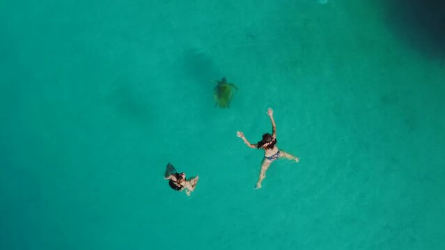Swimming lovers in a turquoise water of Oludeniz Bay in Fethiye Turkey - swimming with a big caretta turtle.