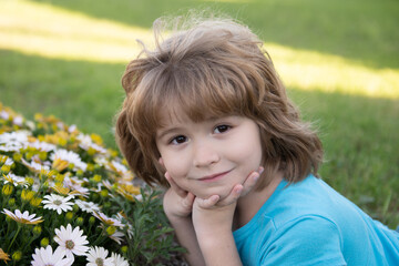 Cute little child boy picking flowers in blooming summer garden. Spring child face. Happy little child with flowers on the grass in a summer. Cute little child on the meadow in backyard.