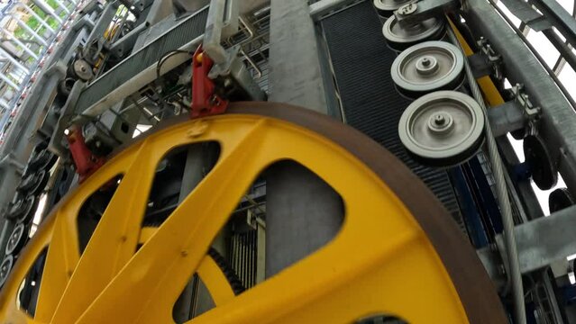 Large yellow metal wheel for turning the cable of the ski lift