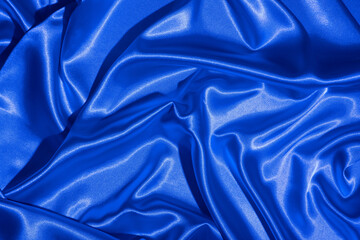 Textiles folds in neon blue-pink light. Trendy colors and shiny abstract background