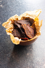 Beef jerky meat. Dried sliced meat in bowl.