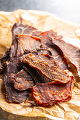 Beef jerky meat. Dried sliced meat on paper.