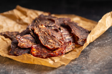 Beef jerky meat. Dried sliced meat on paper.
