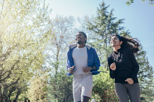 view from below of multi-ethnic runner couple joggin in park