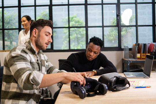 Young creative or product designers comparing and analysis virtual reality glasses for tech development with team in the office studio. future technology improvement.