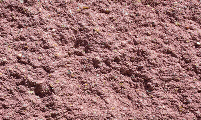 Textura y fondo de pared rugosa y áspera de cemento coloreado de rojo