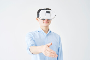 白バックでVRゴーグルをつけて握手する男性